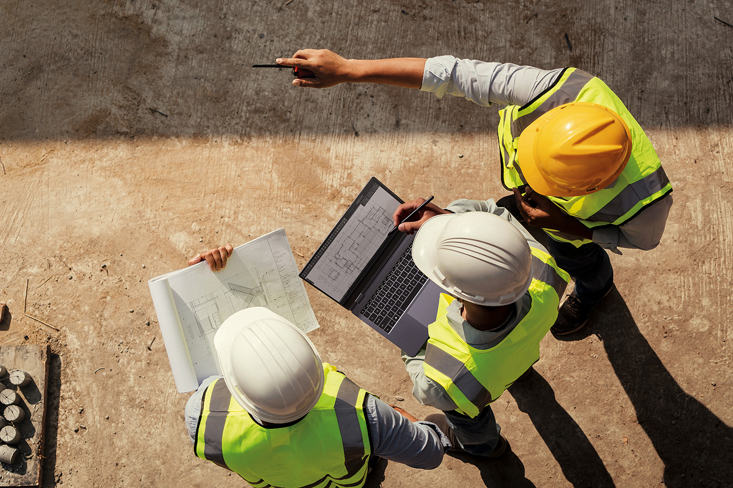 Construction workers editing site plans on a Galaxy Book PC